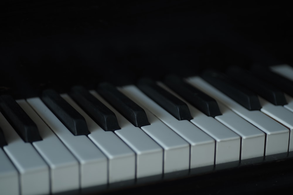 a close up of a piano keyboard with black and white keys