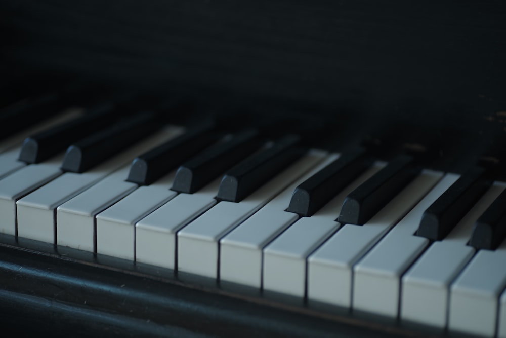 a close up of a piano keyboard with black and white keys