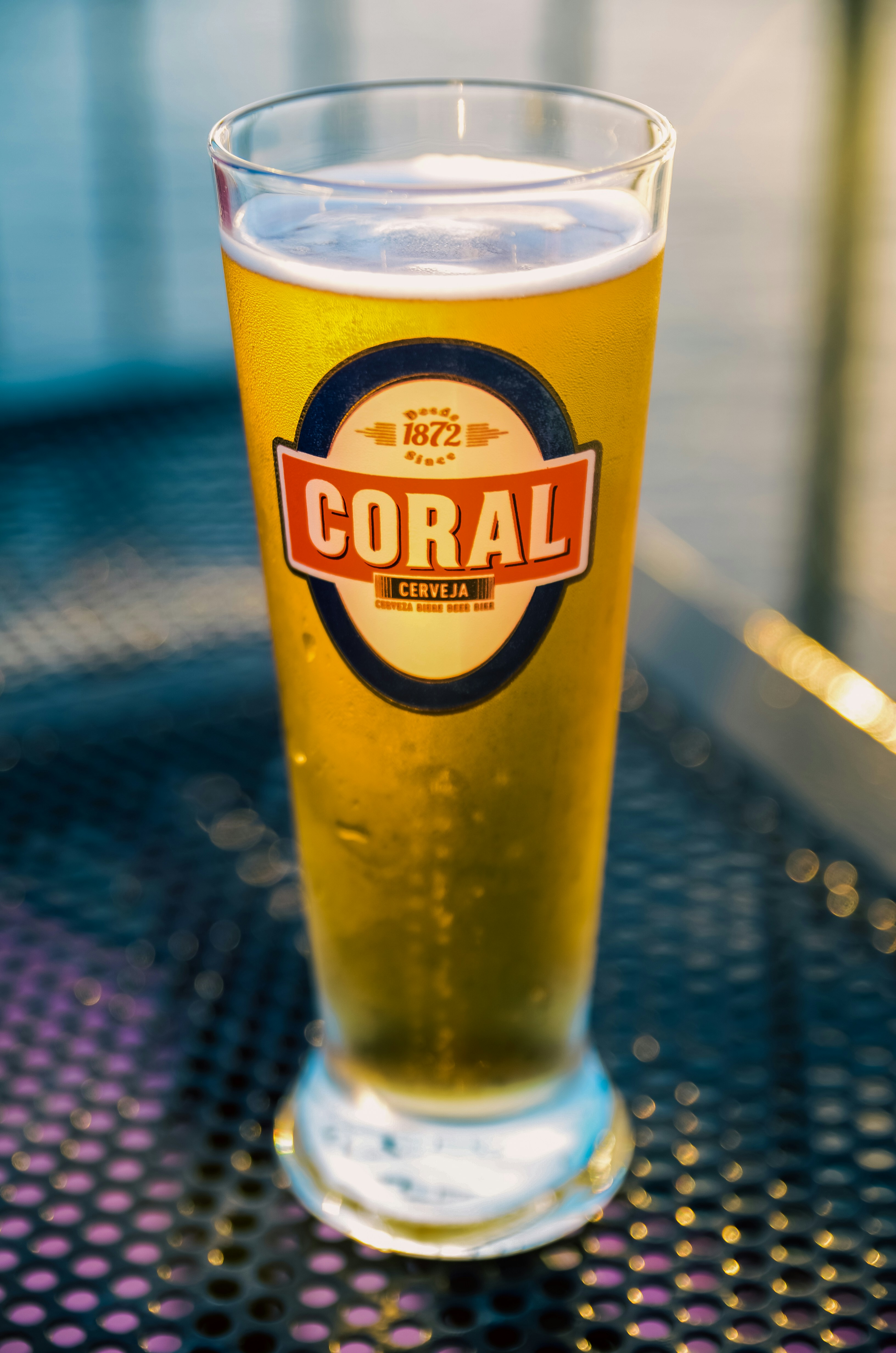 a glass of beer sitting on top of a table