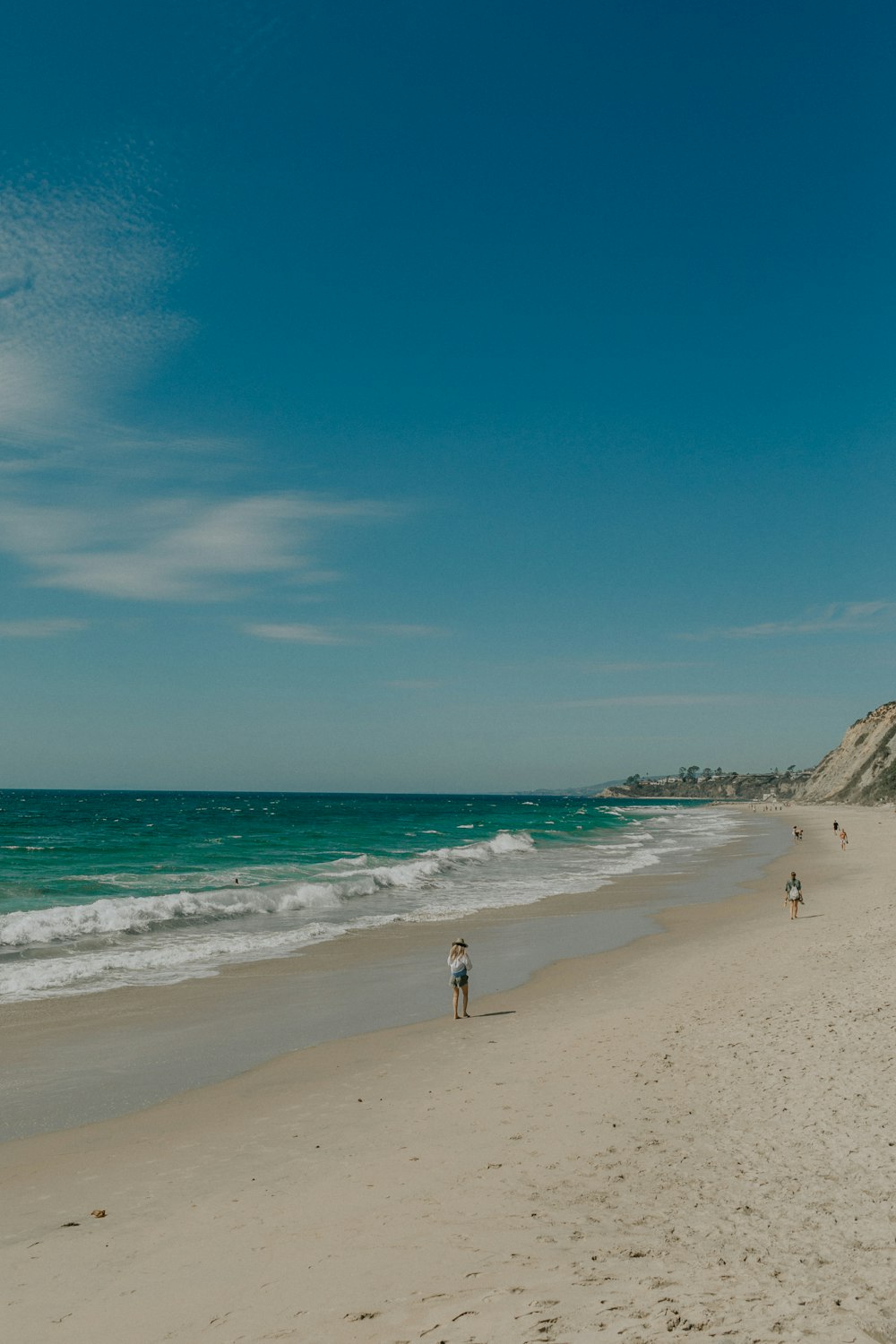 a group of people standing on top of a sandy beach