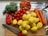 Man happily unpacking groceries with fresh vegetables on the kitchen counter