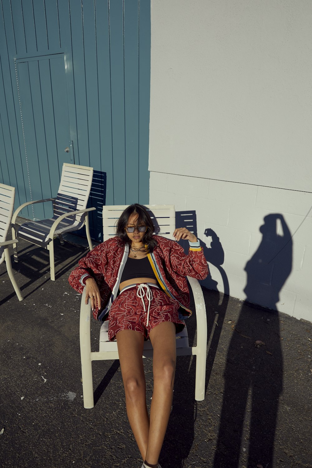 a woman sitting in a chair with her shadow on the wall