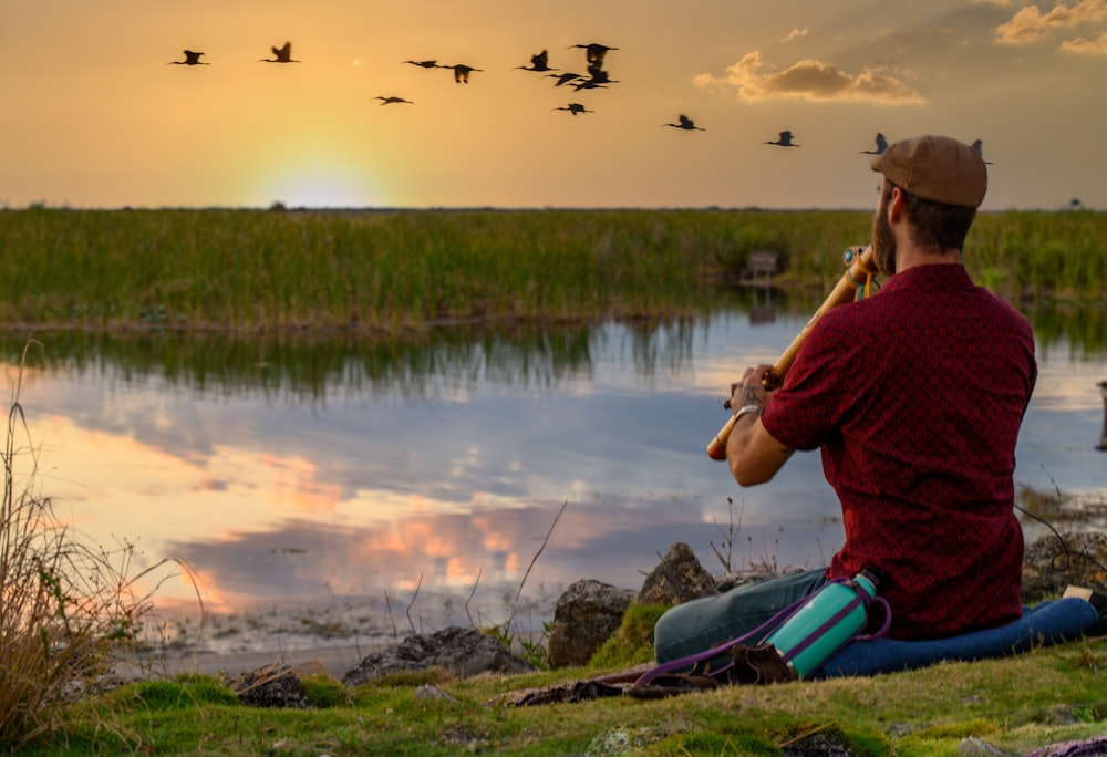 a man sitting on the ground playing a flute