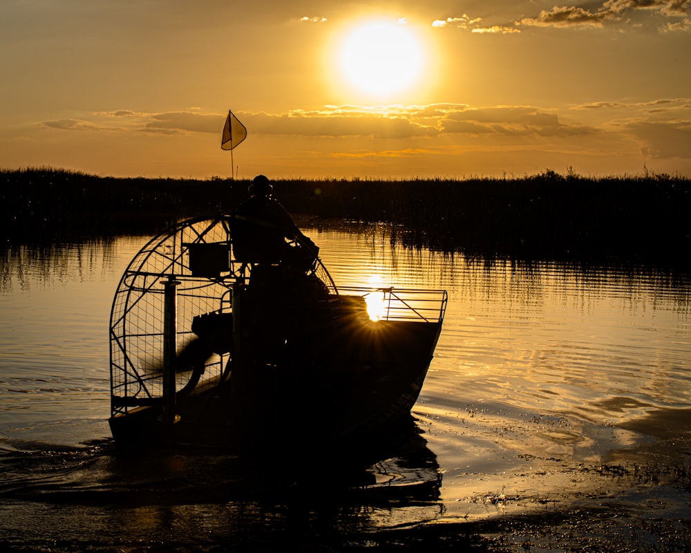 a boat in a body of water at sunset