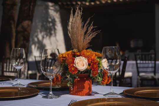 a table with a vase of flowers and plates