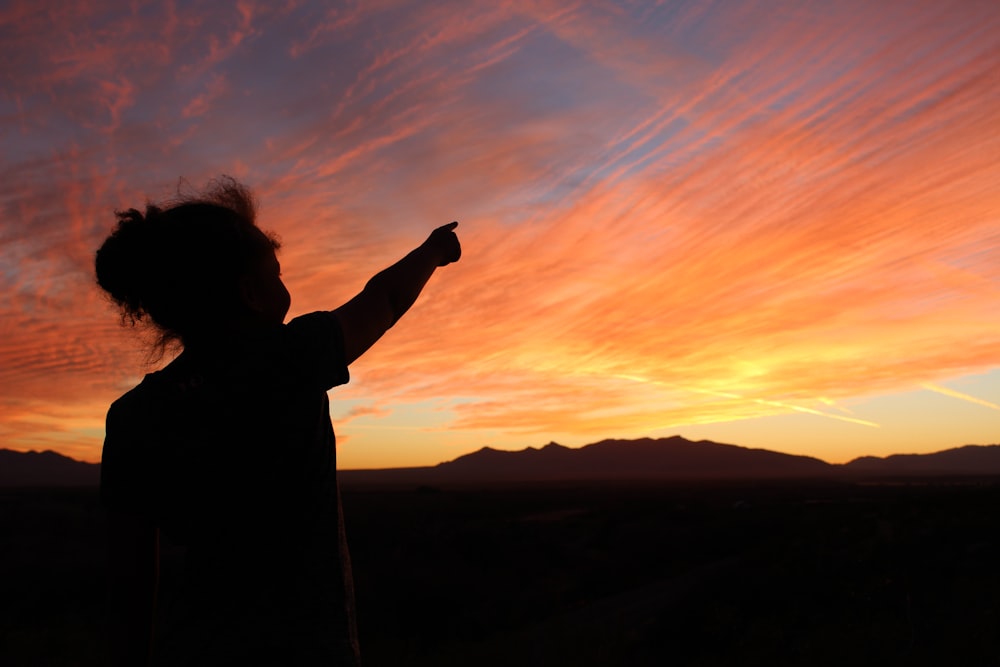 a person standing in front of a sunset