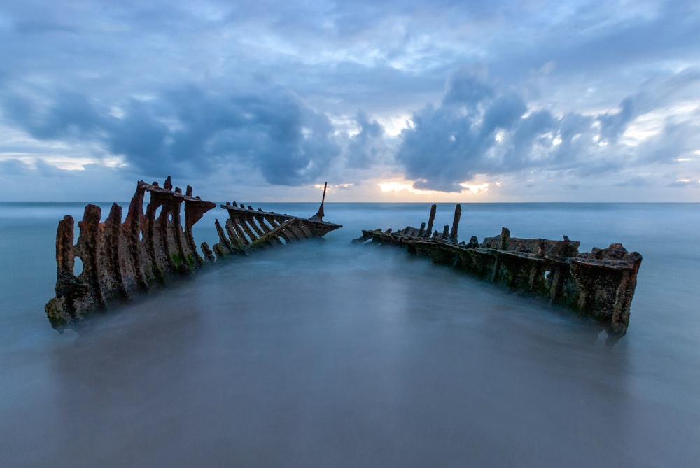 a long exposure photo of a ship wreck in the ocean