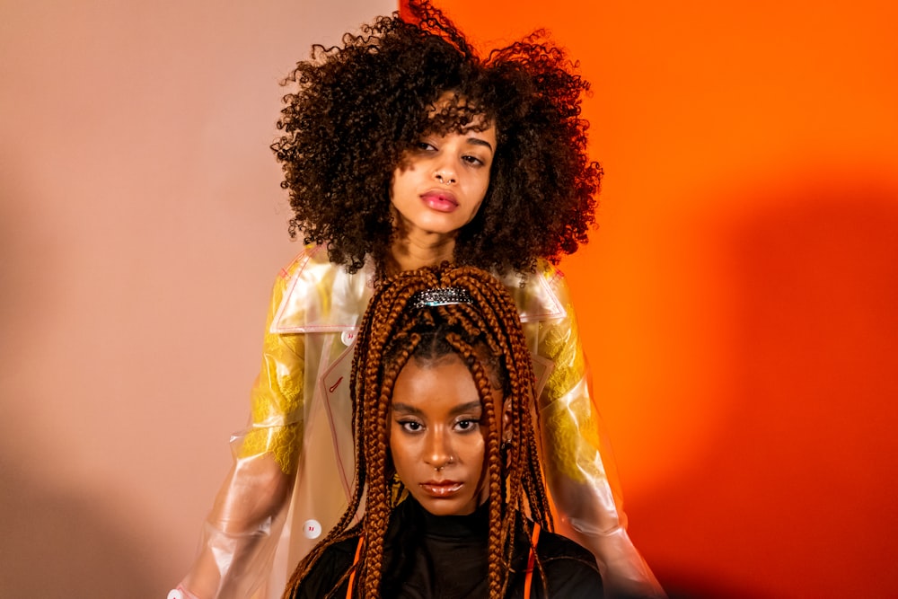 a woman with long hair standing next to another woman