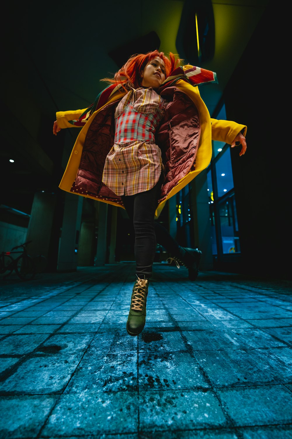 a woman in a red and yellow coat is dancing
