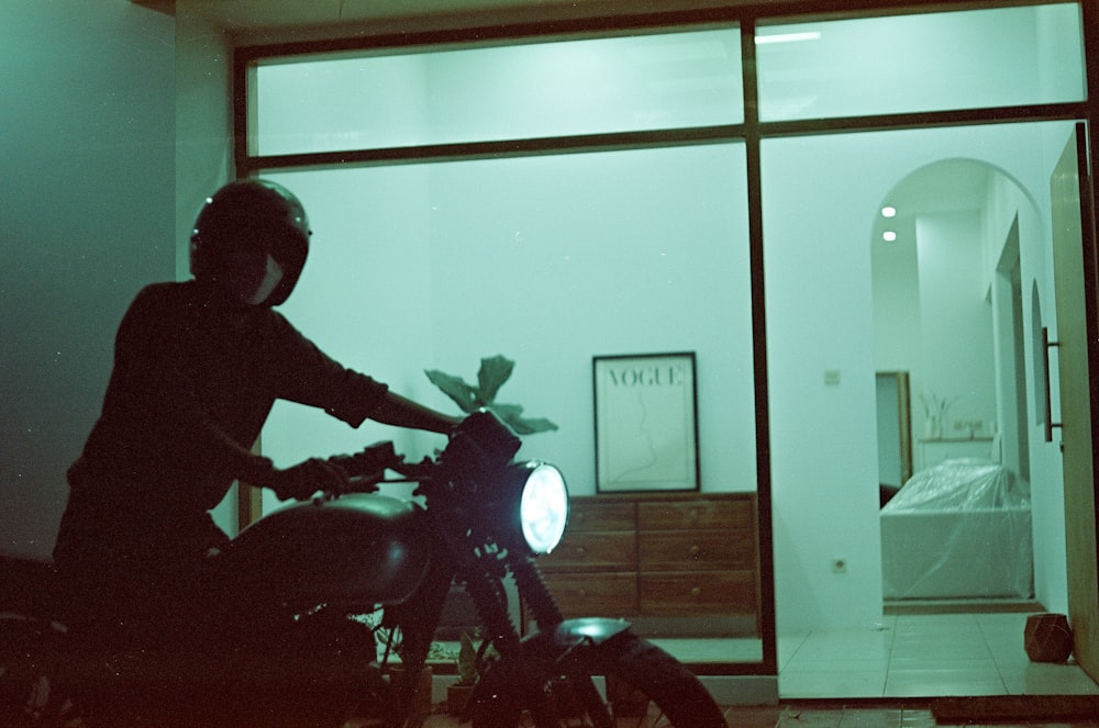 a person riding a motorcycle in front of a window