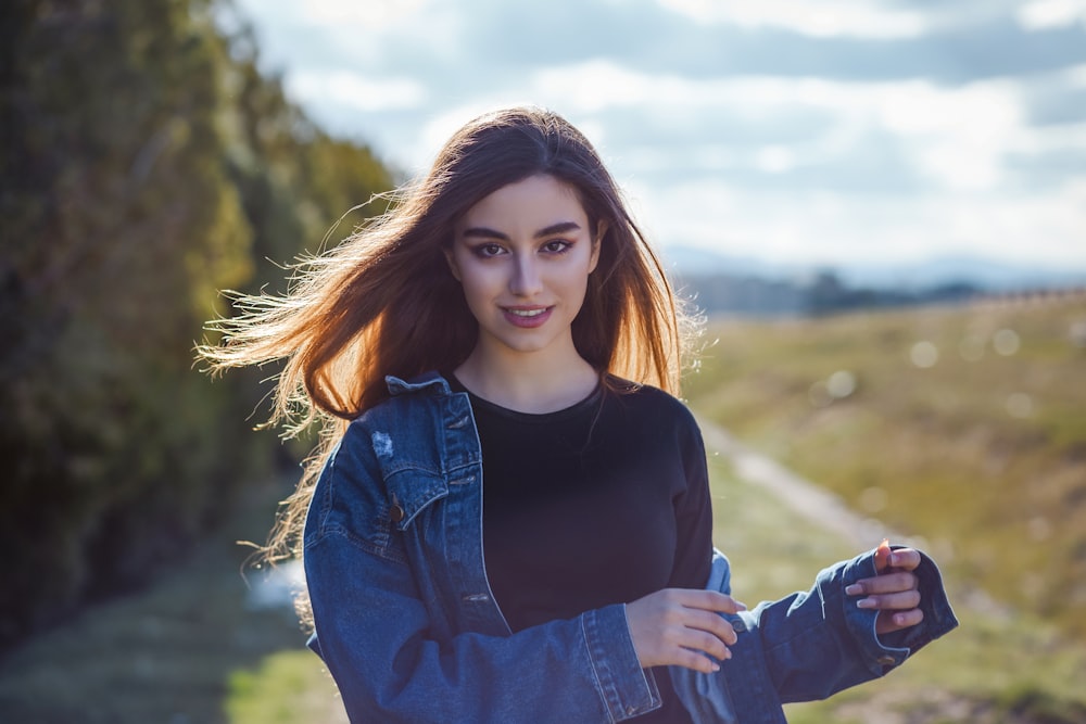 a woman in a black shirt and jean jacket