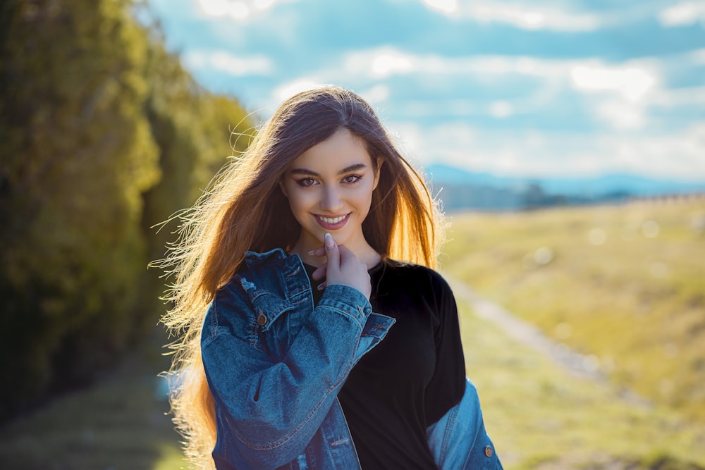 a young woman posing for a picture in a field