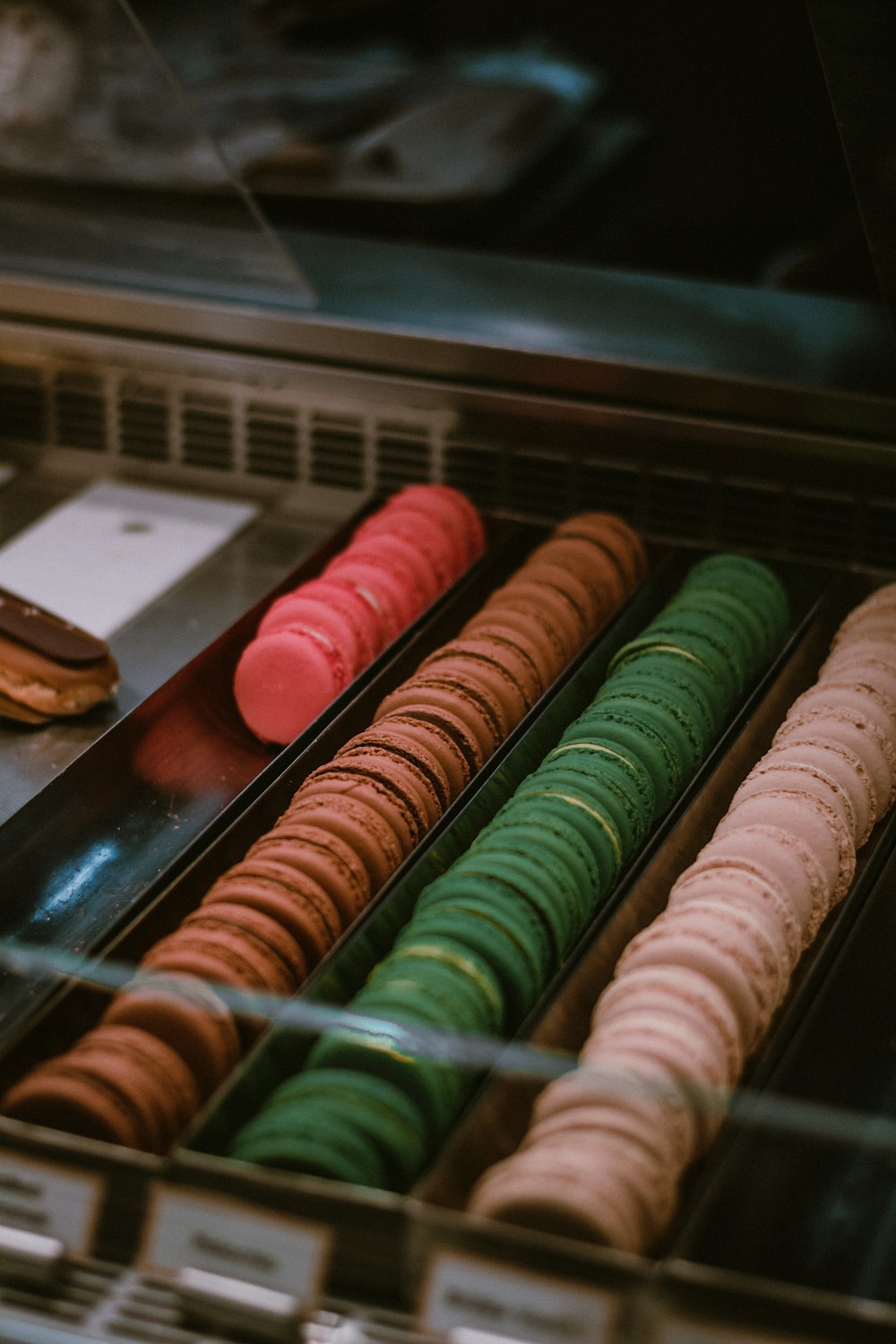 a display case filled with lots of different colored donuts