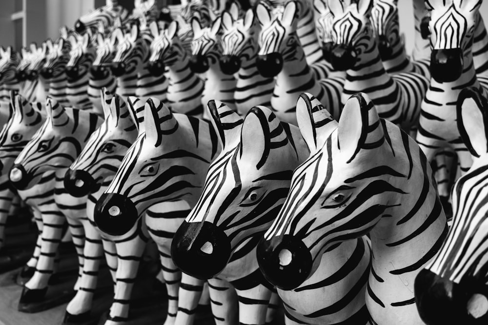 Una fila di sculture di testa di zebra in bianco e nero