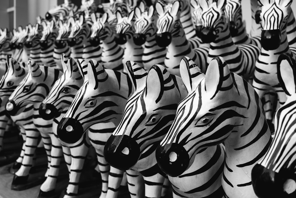 a row of zebra head sculptures in black and white