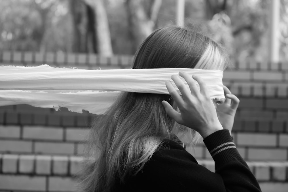 a woman covering her eyes with a white sheet