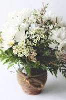 A colorful mix of tulips and daisies arranged in a rustic basket.