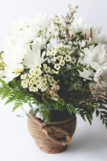 A colorful mix of seasonal flowers in a rustic basket ready for delivery.