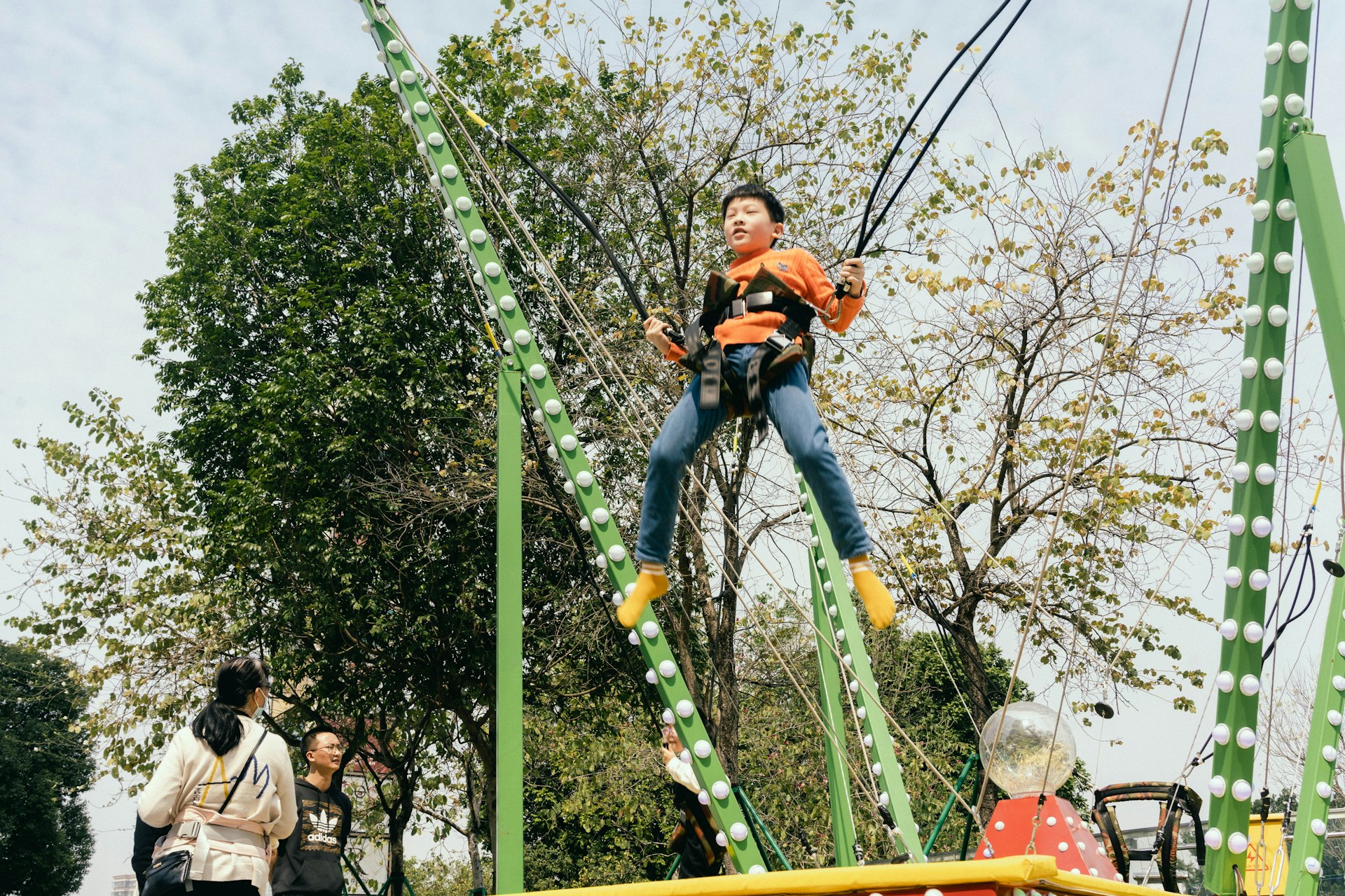 a man riding a zip line on top of a roller coaster