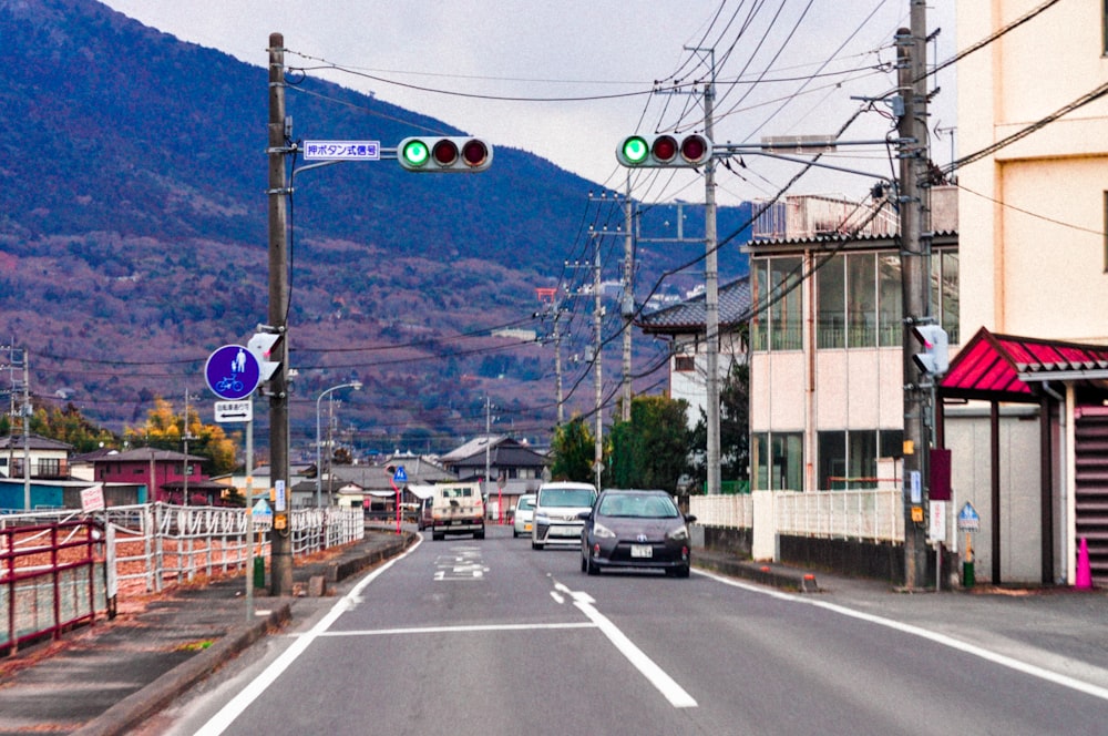 a car is driving down a street with mountains in the background