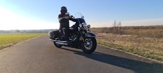A happy rider cruising on a scenic open road with a clear blue sky.