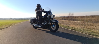 A happy rider cruising on a scenic open road with a clear blue sky.