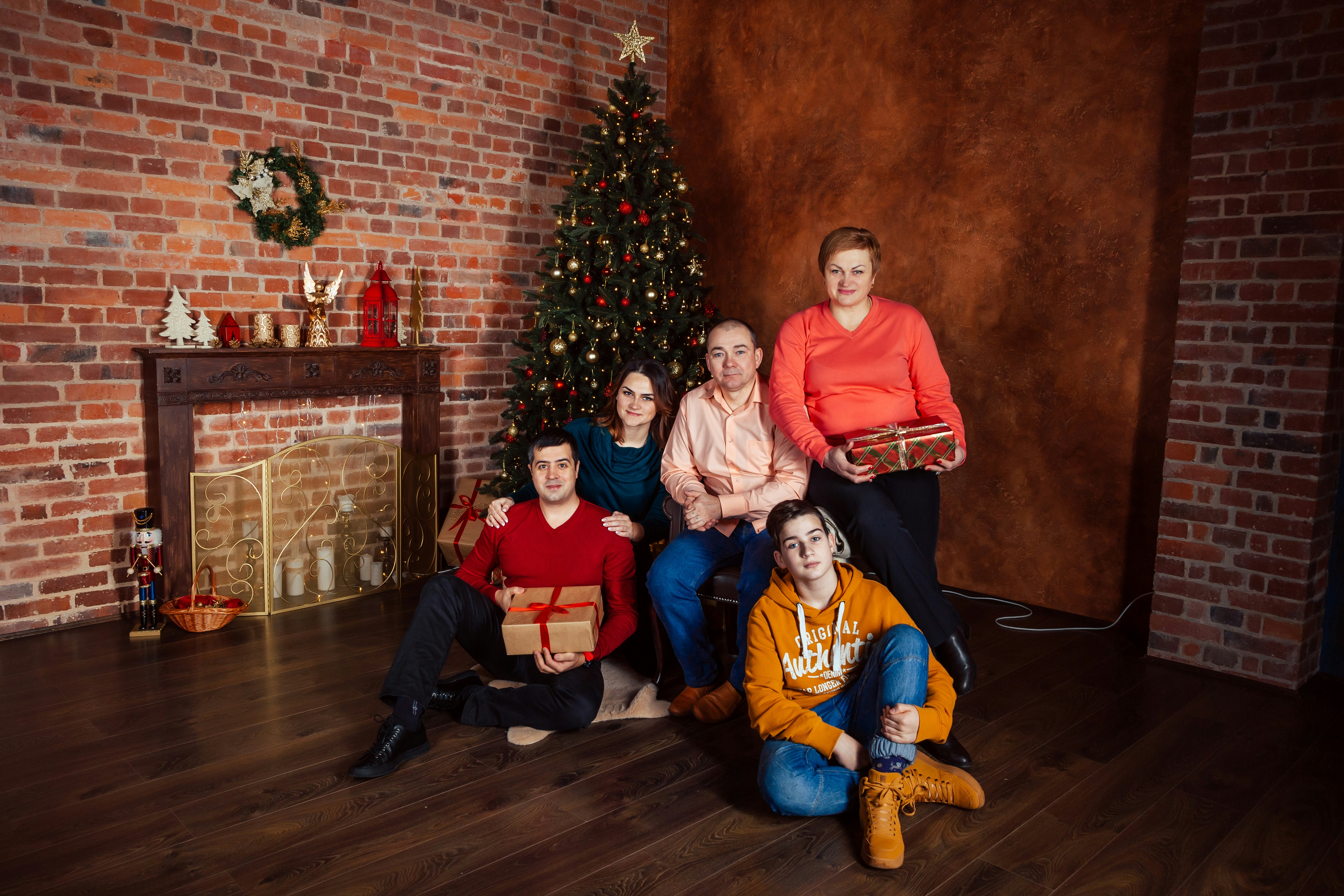a group of people sitting in front of a christmas tree