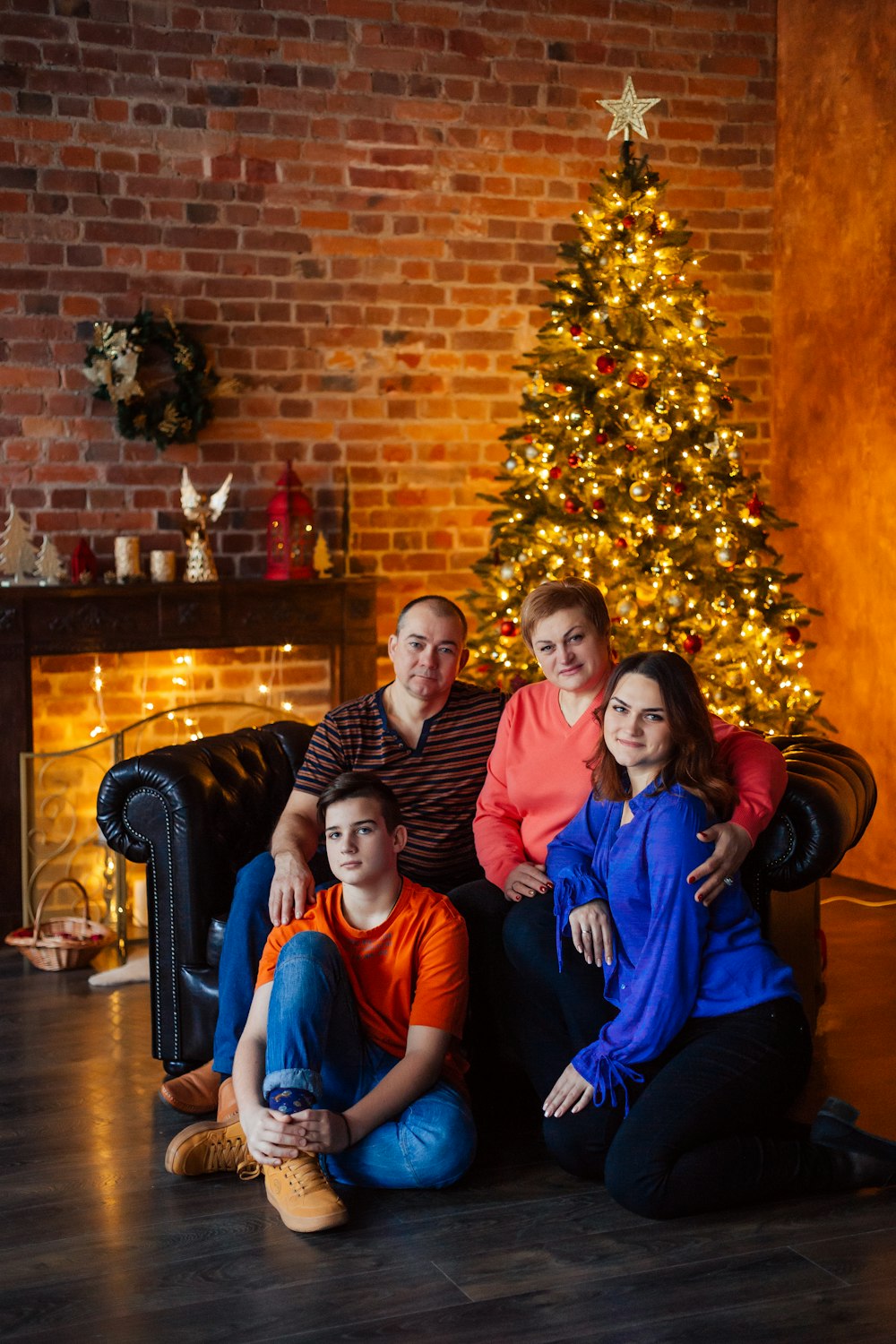 Une famille assise devant un sapin de Noël