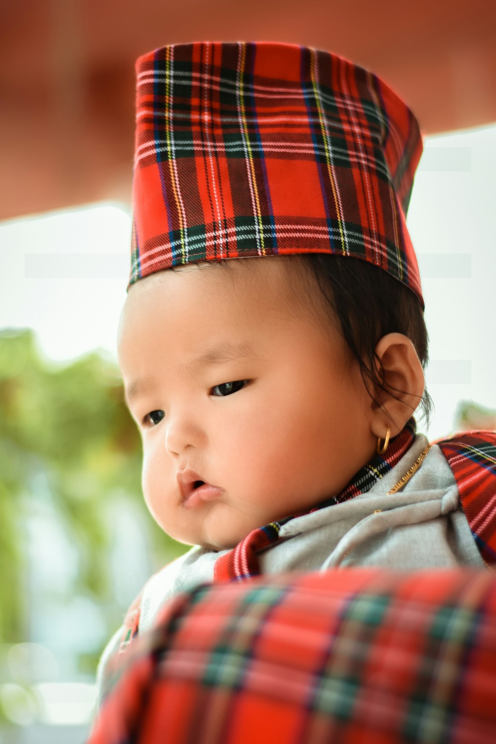 a small child wearing a red plaid hat