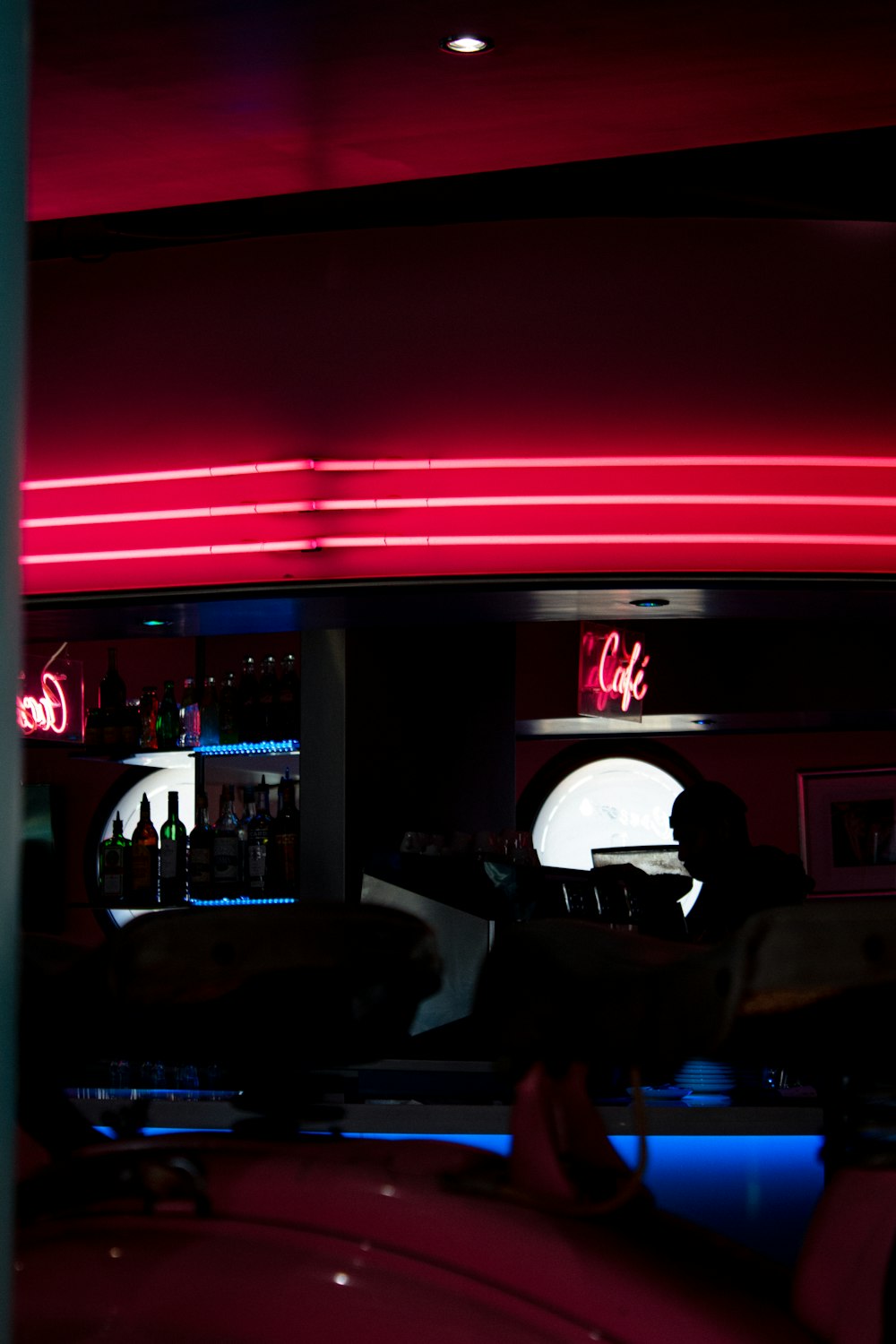 a car parked in front of a bar with neon lights