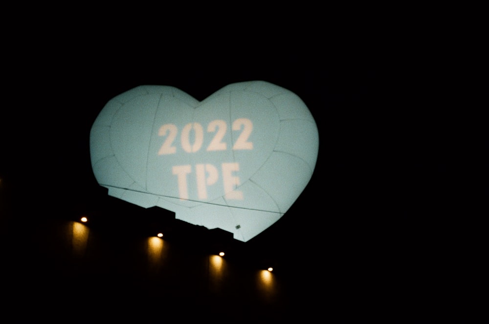a large heart shaped balloon with the words 2012 tpe projected on it