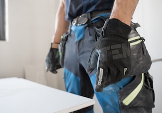 a man wearing a pair of black and blue work gloves