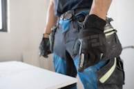 a man wearing a pair of black and blue work gloves