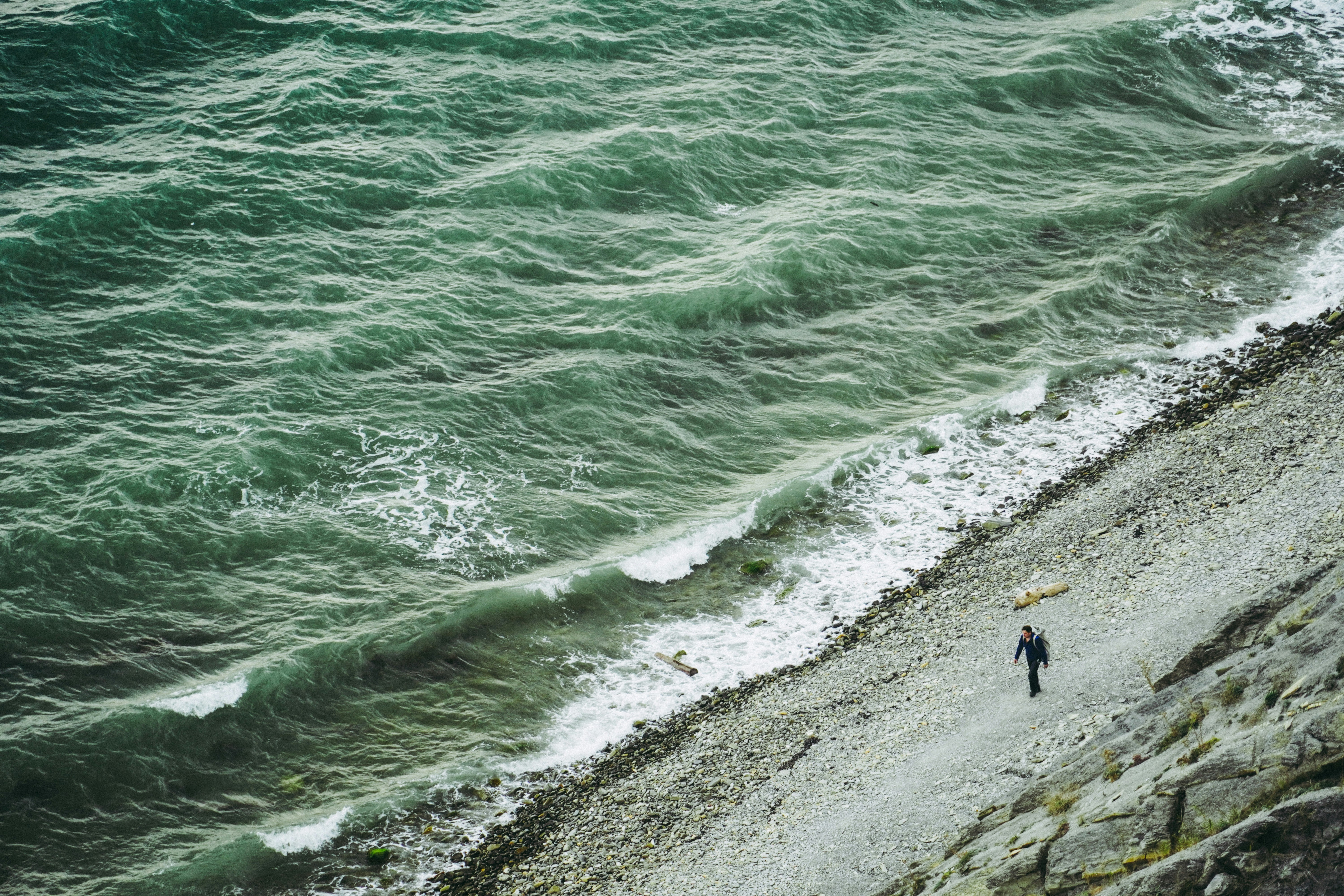 a person standing on a beach next to the ocean