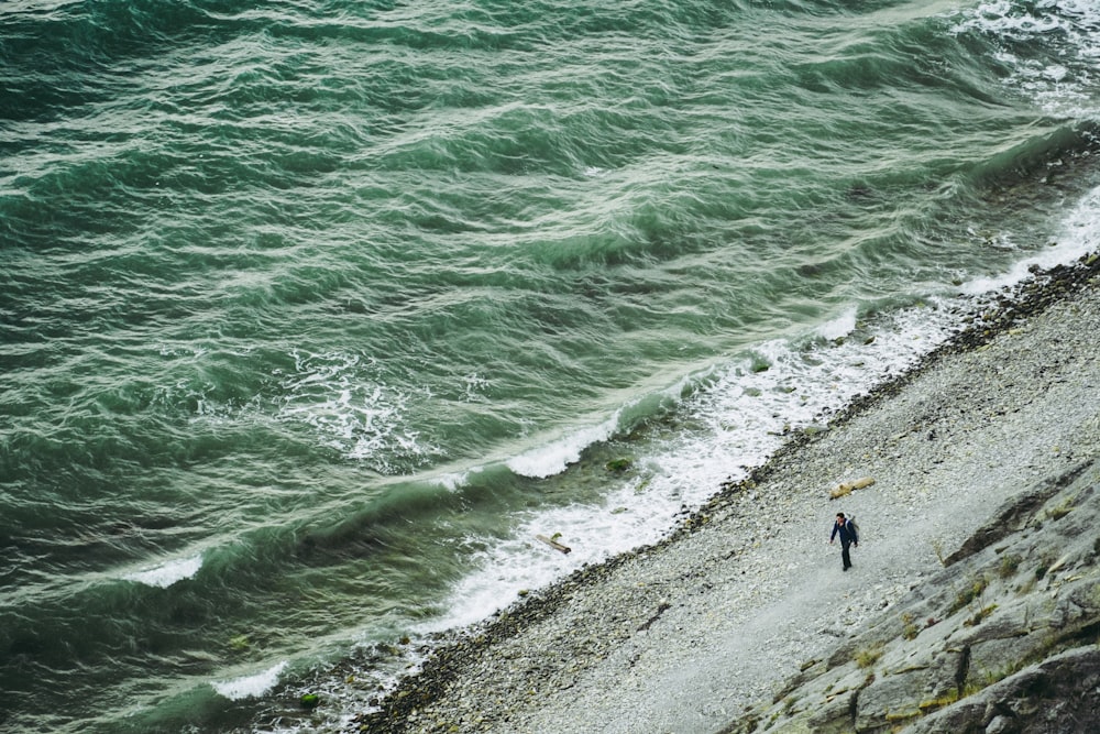 une personne debout sur une plage au bord de l’océan