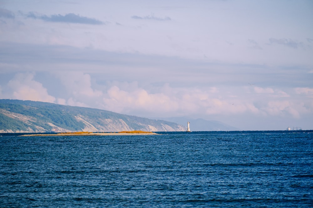 a large body of water with mountains in the background