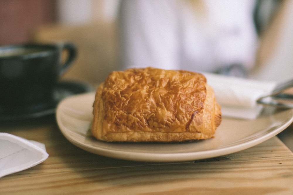 a piece of bread sitting on top of a white plate