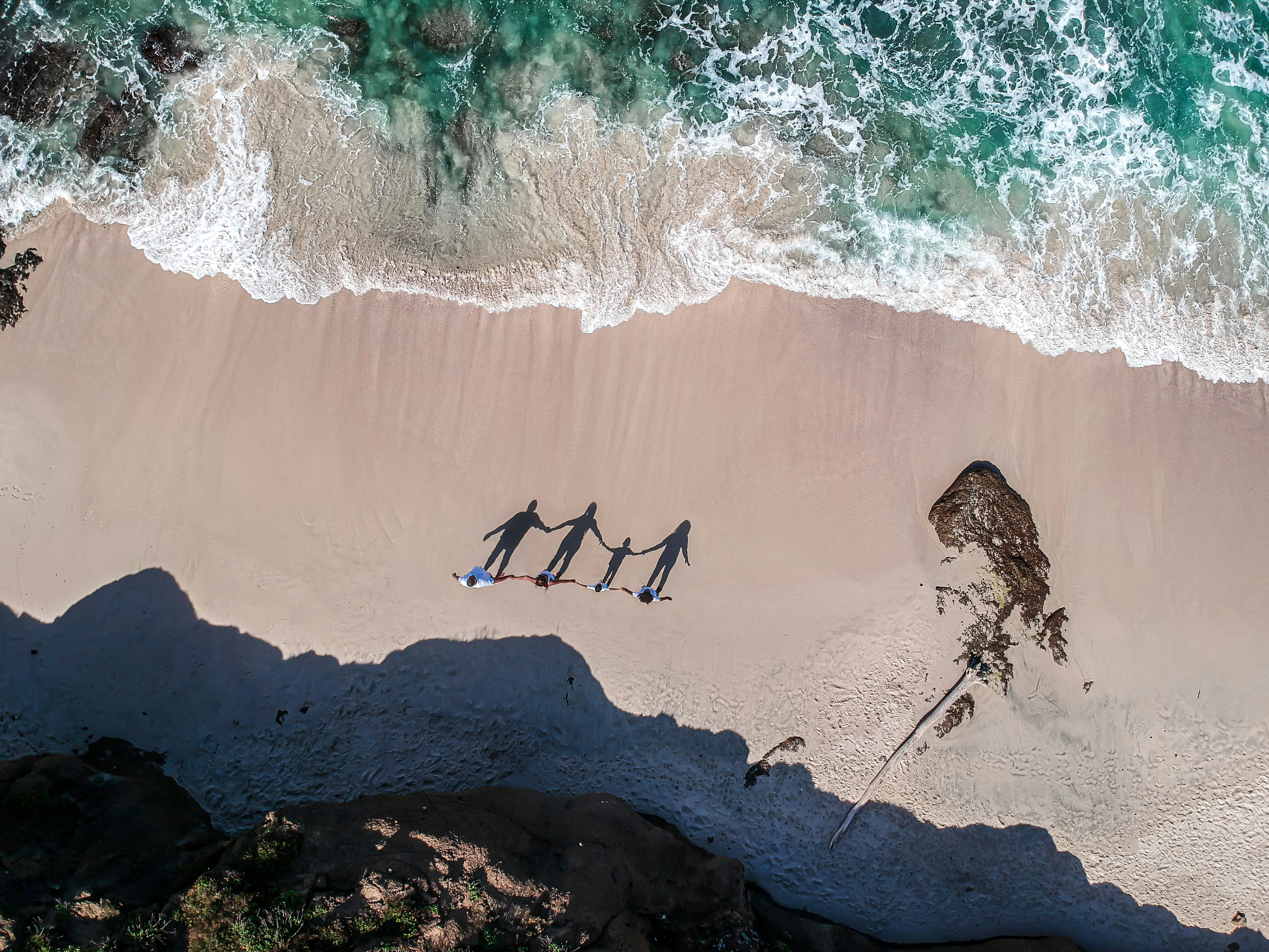 a group of people standing on top of a sandy beach