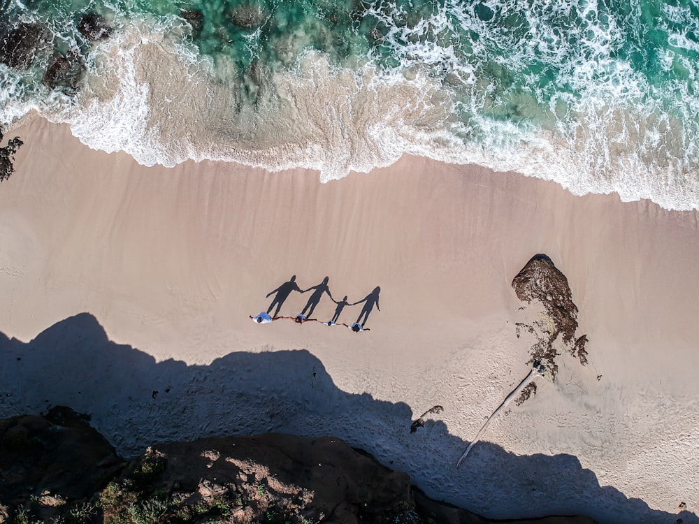 a group of people standing on top of a sandy beach