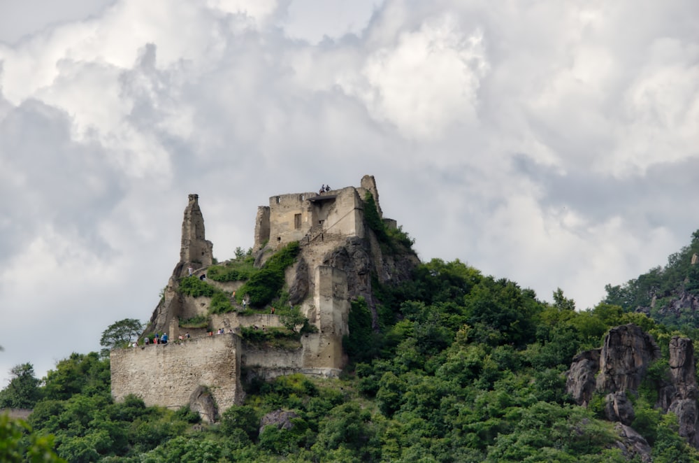 Un castillo sentado en la cima de una exuberante ladera verde