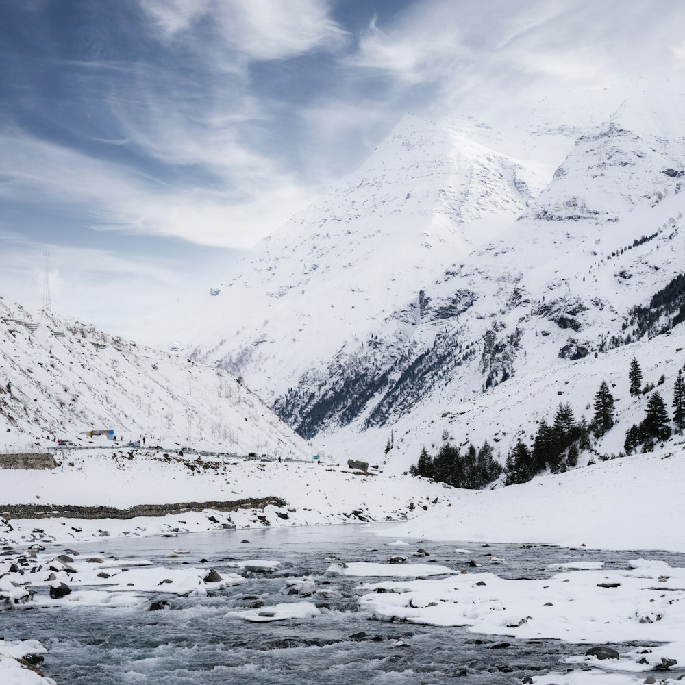 a mountain covered in snow with a river running through it