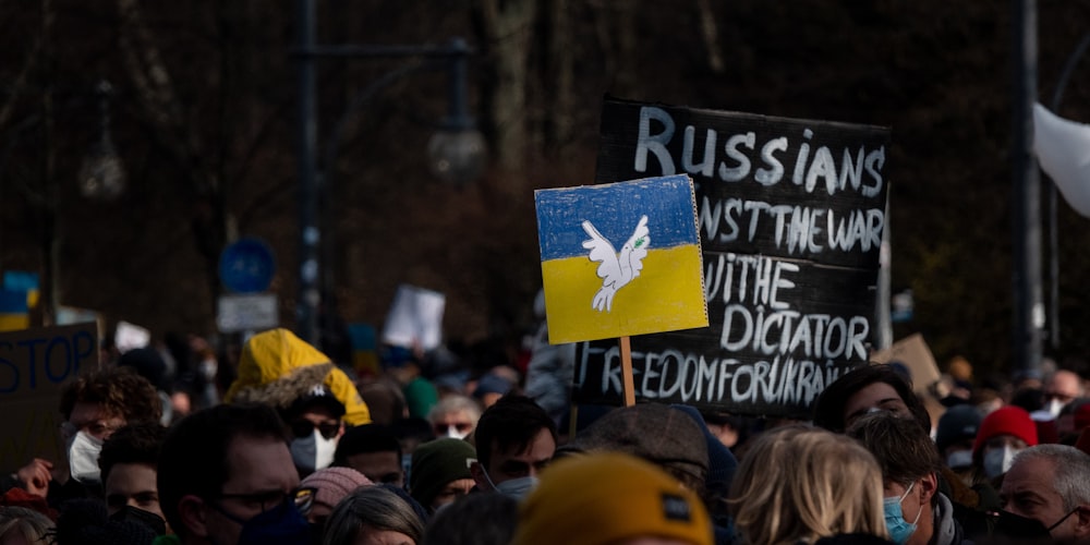 a crowd of people holding signs and flags