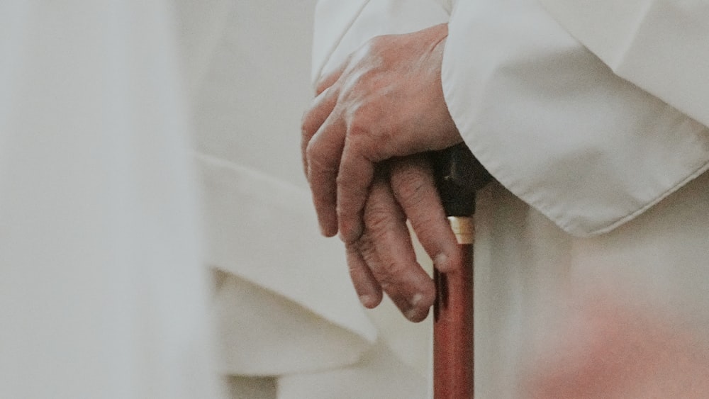 a close up of a person holding a cane