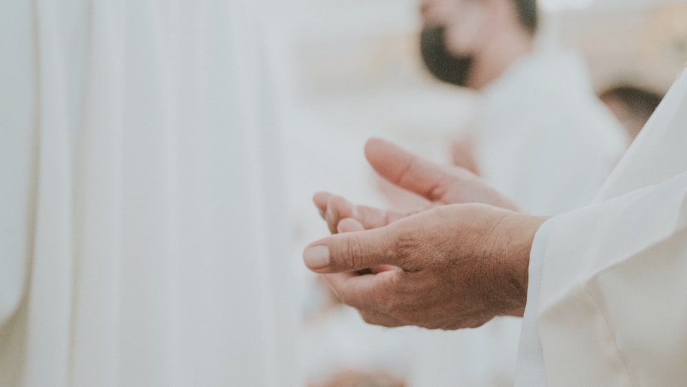 a close up of a person holding their hands together