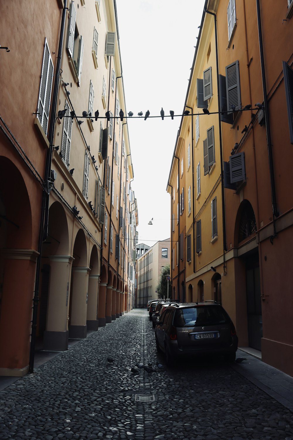 a car is parked on a cobblestone street