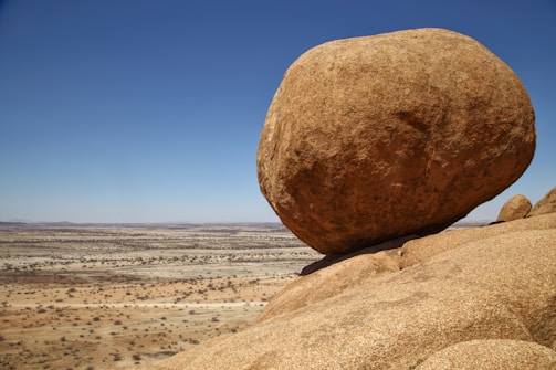 a large rock in the middle of a desert
