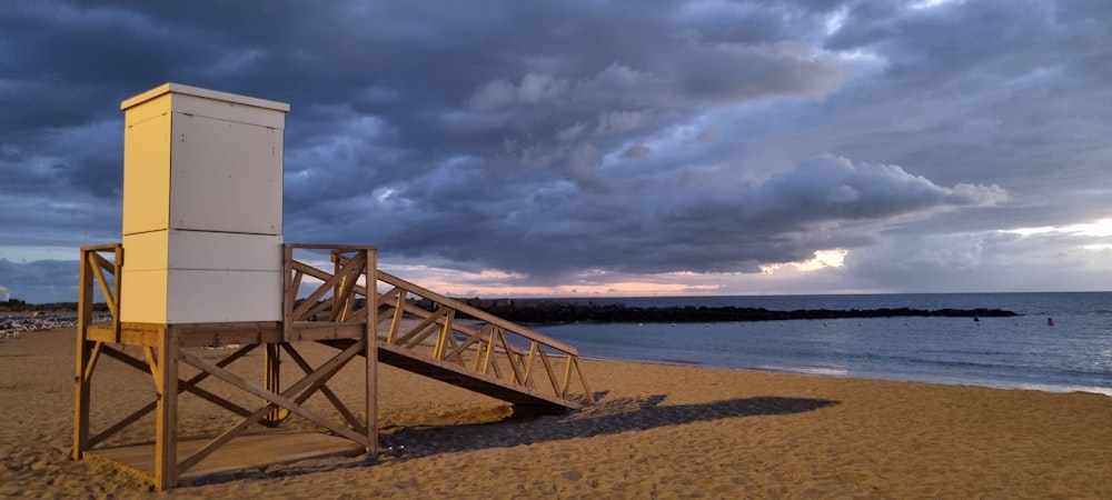 a lifeguard tower sitting on top of a sandy beach