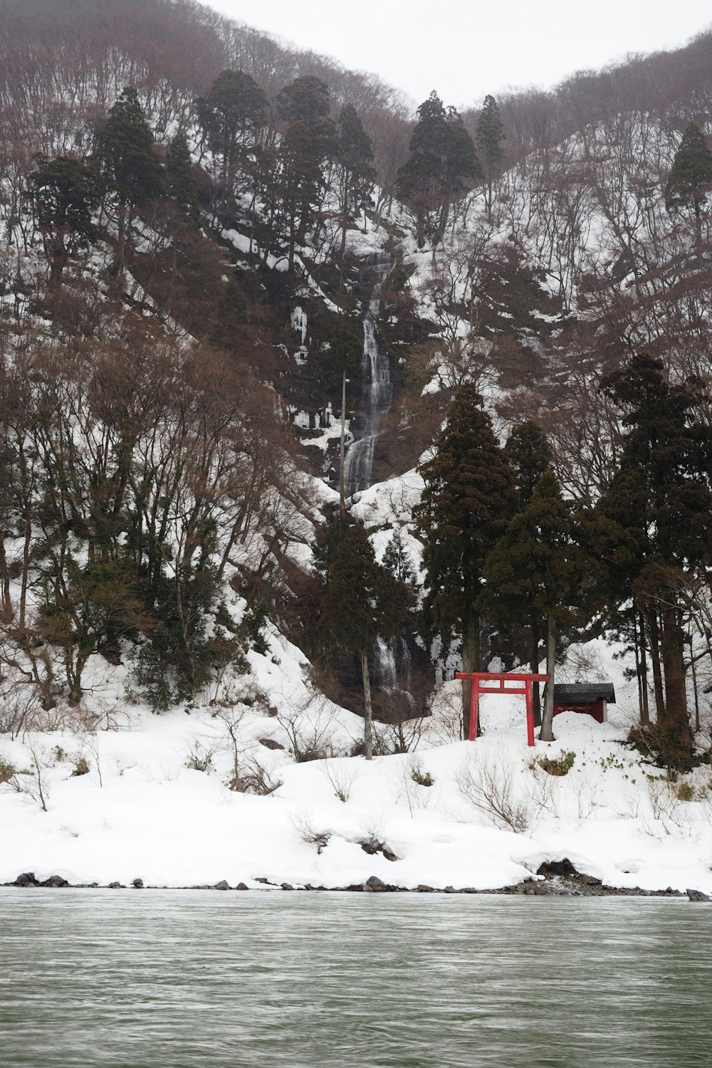 a snowy mountain with a waterfall in the distance