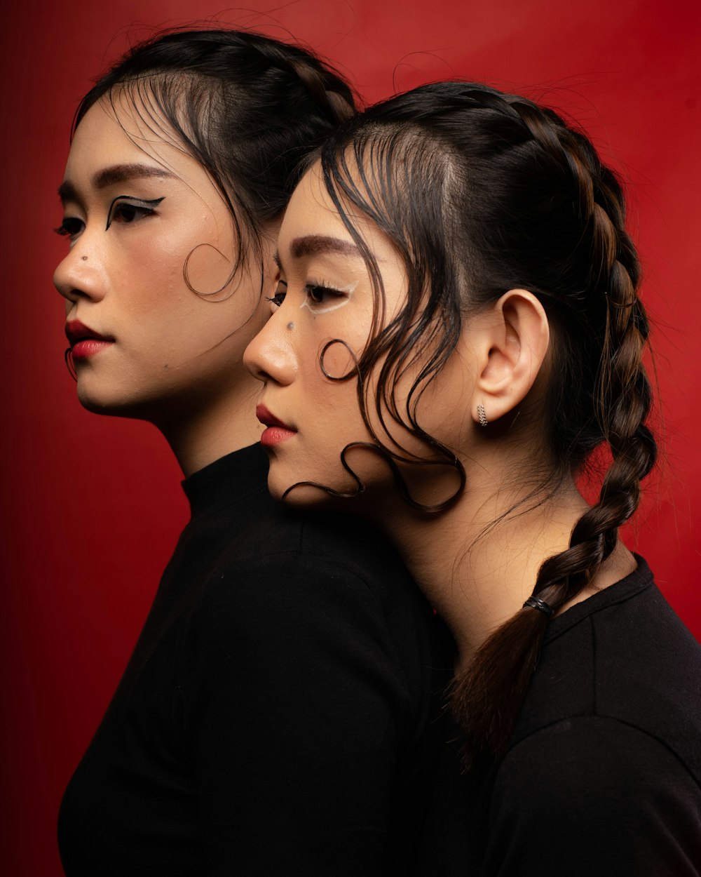 two asian women with hair in a braid