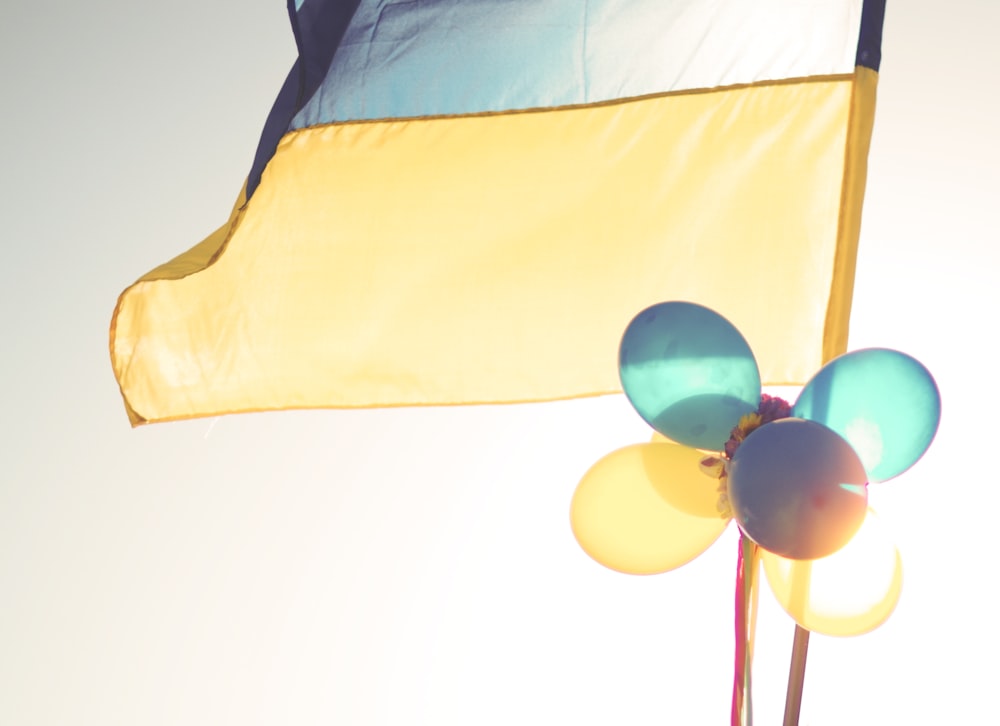 una bandera amarilla y azul y algunos globos